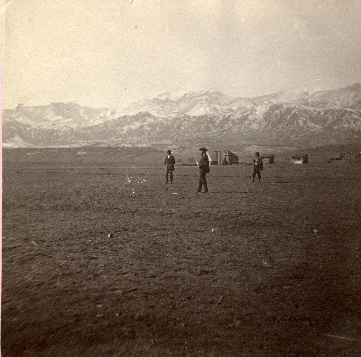 An historic image of a stereoview card showing men on the treeless prairie at the site of Colorado Springs circa 1871 (credit: Colorado Springs Pioneers Museum)