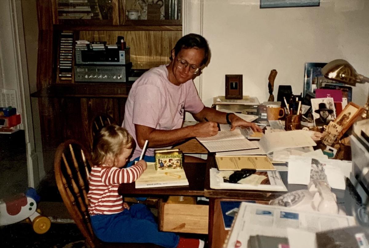 Mark Hesse at work while daughter Hartley sits nearby. Hesse was busy developing what would be Rocky Mountain Field Institute in the 1980s. Courtesy of Hartley Hesse.