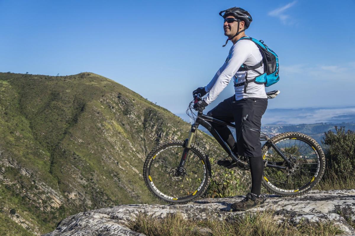Mountain biker paused on a rock to look at the mountains